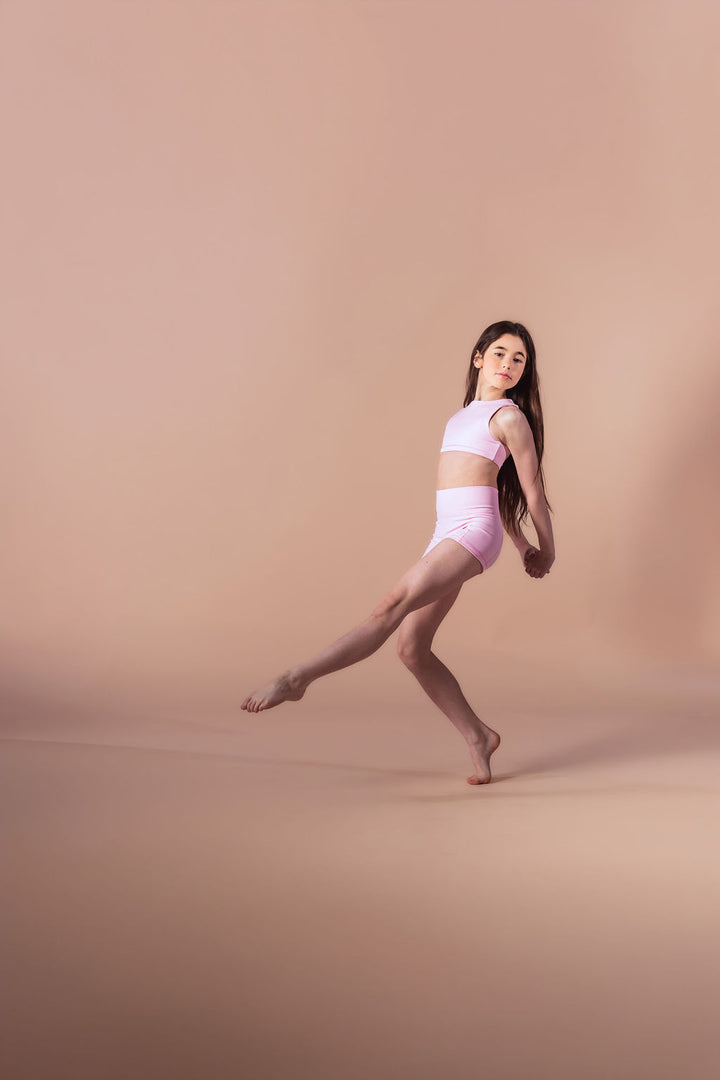 Dancer in a white outfit posing on a beige background